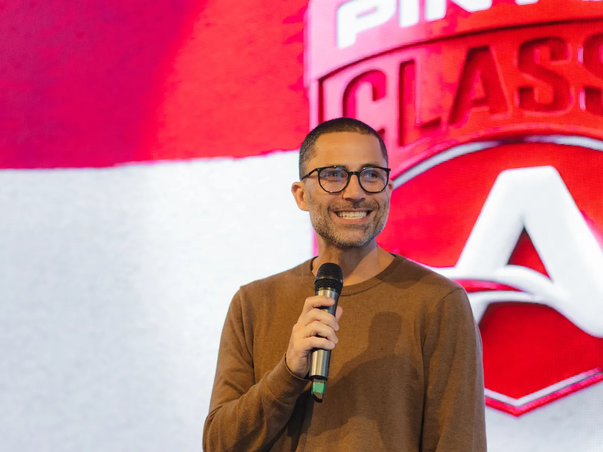 Charles G. Martins sorrindo no palco do evento Classe A